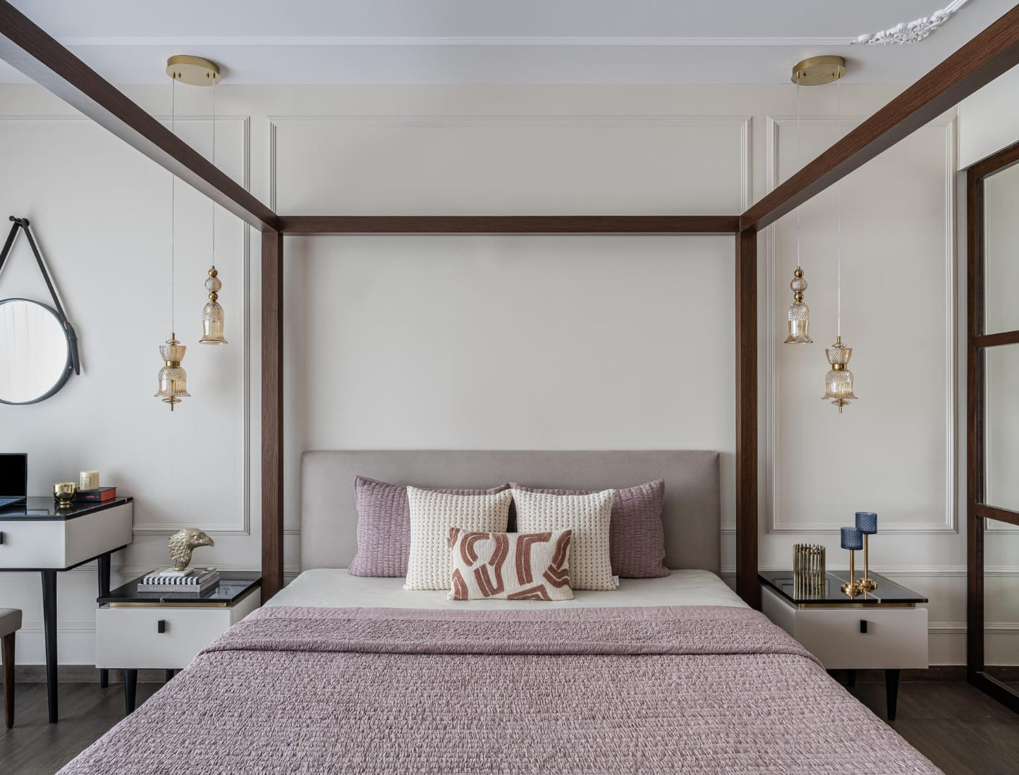 Modern bedroom with a canopy bed, decorative pillows, and wall lights, pink bed cover.