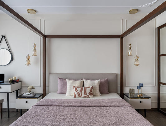 Modern bedroom with a canopy bed, decorative pillows, and wall lights, pink bed cover.